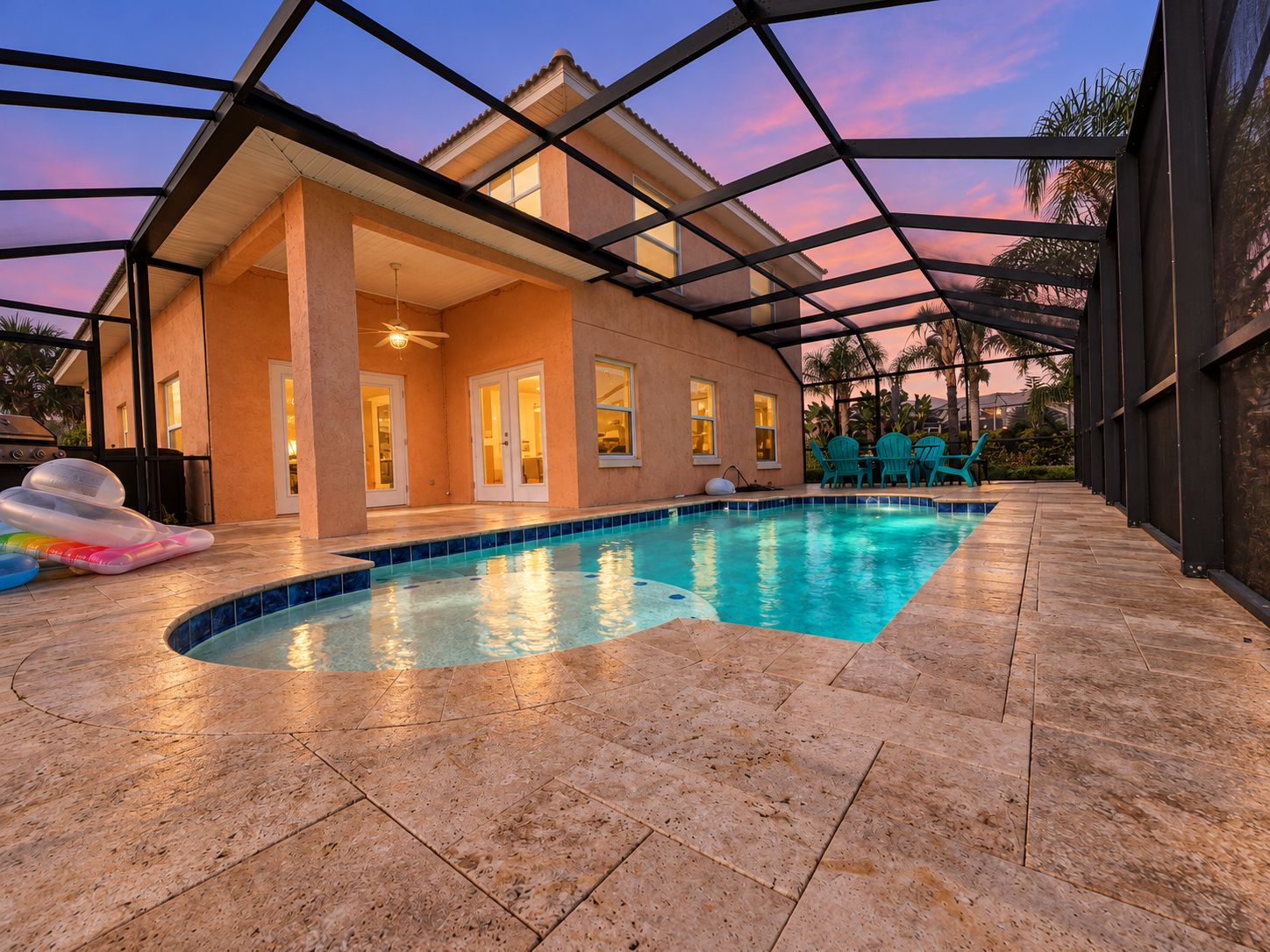 A swimming pool with a covered patio area, a ceiling fan, and a view of a house.