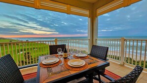 Mesa para dos con vista al océano y a un campo de golf.