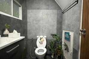 A bathroom with a toilet, a shower, a sink, and a potted plant. - New York Loft & Japanese Magic by V4Skin (Bangkok)