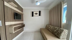 A modern living room with a sofa, TV, and built-in shelves. - diRoma Lacqua Caldas Novas (Caldas Novas)