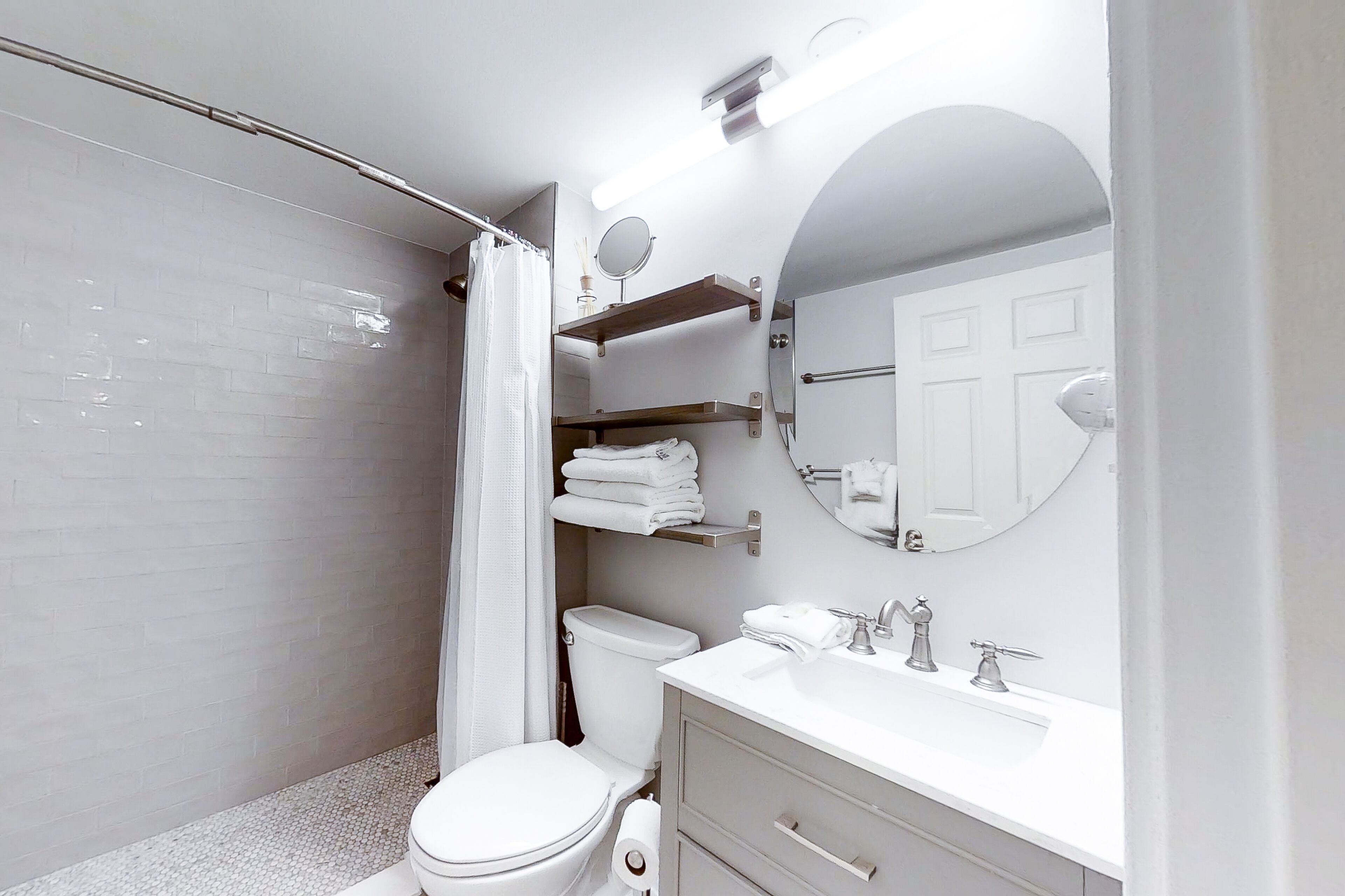 Un baño moderno con inodoro, lavamanos y ducha.