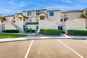 A modern apartment complex with a parking lot in front.