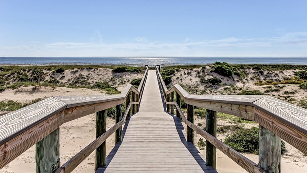 A wooden boardwalk leading to a beach with sandy dunes and a clear sky. - Lovely oceanfront townhouse in Summer Beach Village w/Shared Pool, Central AC (Fernandina Beach)