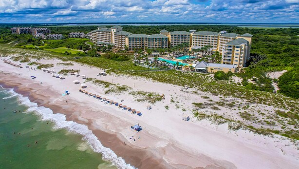 A resort with multiple buildings, a beach, and a pool area.