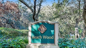 A sign with the name 'Beach Wood' surrounded by lush greenery.
