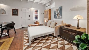 A cozy bedroom with a bed, a sofa, a wooden side table, and a lamp. - El Vaso Lleno - Fantastic Location, Historic Home (Santa Fe)