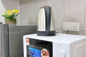 A microwave with a digital display and a kettle on top. - JetPad Suites - Near KLIA (Dengkil)