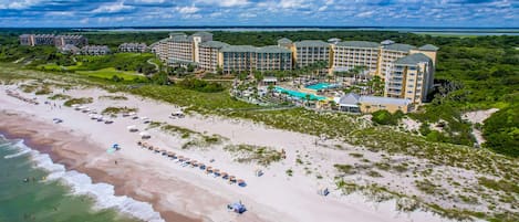 A resort with multiple buildings, a beach, and a pool area.