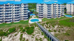 Un hôtel de grande hauteur doté de nombreux balcons, d’une piscine et d’un pont reliant les différents bâtiments.