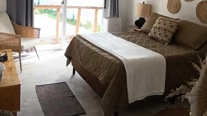 A bedroom with a bed, a desk, a chair, a ceiling fan, and a view of the outdoors. - Lemon Tree El Paredon (Sipacate)