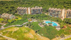 Ein Resort mit mehreren Gebäuden, einem Swimmingpool und umliegender Bepflanzung.
