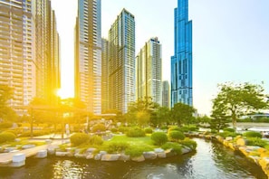 A modern urban landscape with high-rise buildings, a water feature, and well-maintained greenery. - Elysian Landmark Garden (Ho Chi Minh City)