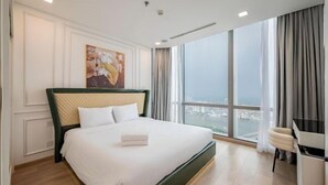 Une chambre d’hôtel avec un grand lit, un bureau et une vue sur la ville.