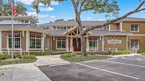 A building with a red door and a sign reading "The Oaks Community Center". - Dog-Friendly Home in the Tennis Villas w/Free WiFi, Shared Pool, Central AC (Fernandina Beach)