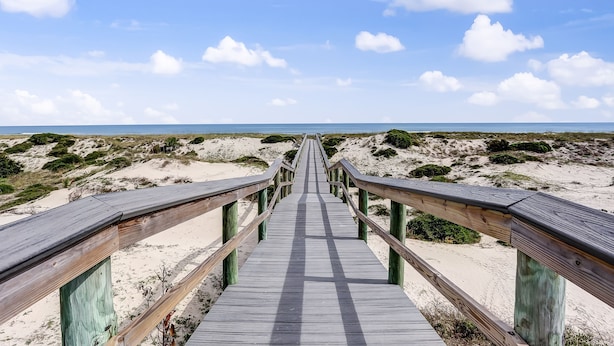 Une promenade en bois menant à la plage.