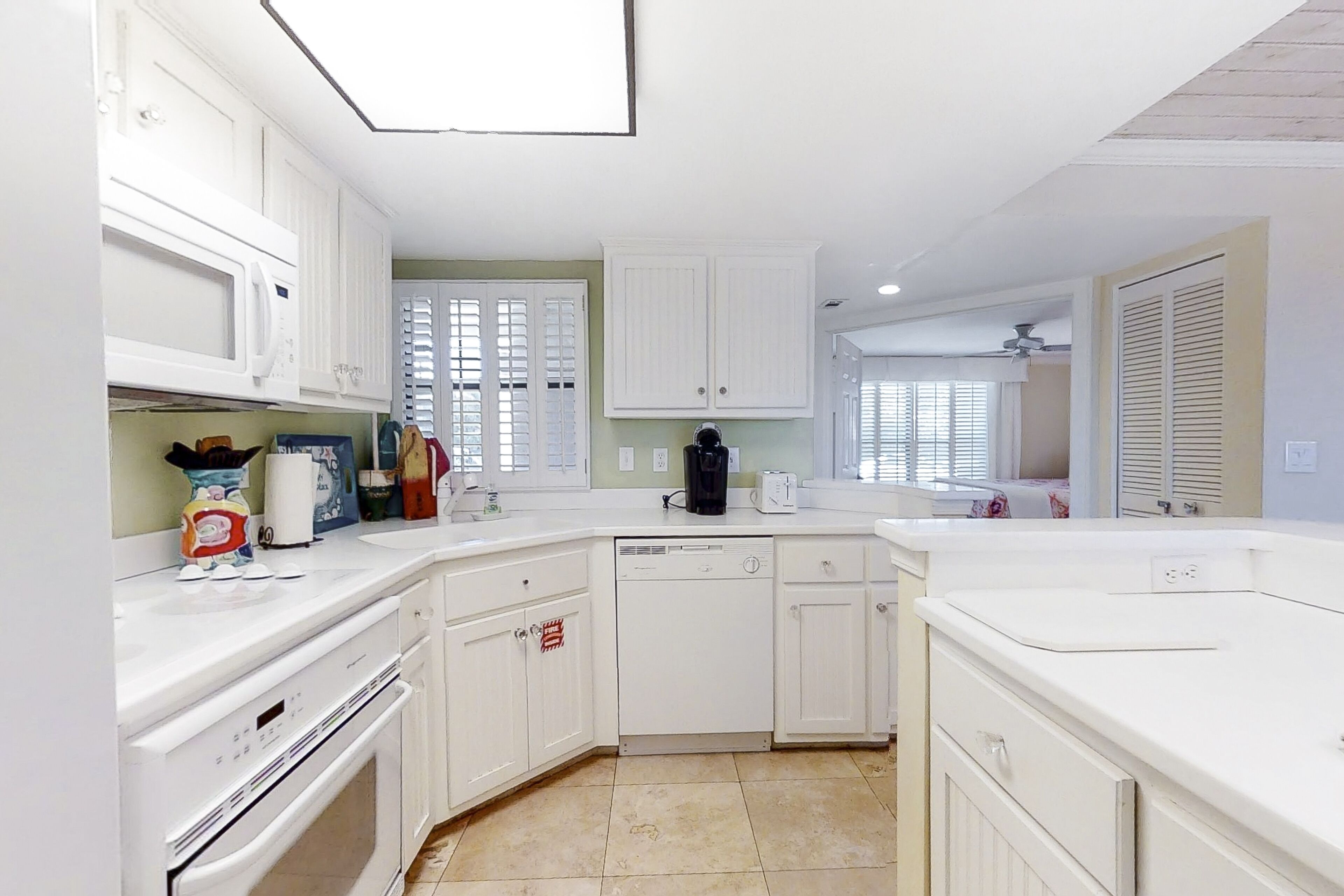 A modern kitchen with white cabinetry, a dishwasher, and a microwave.