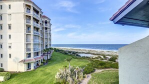 Un hôtel à plusieurs étages doté de balcons donnant sur une plage.