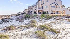 Un hôtel situé en bord de mer, composé de bâtiments à plusieurs étages, doté de balcons et d’espaces de détente en plein air.