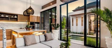 A modern interior with a sofa, dining table, and kitchen area.