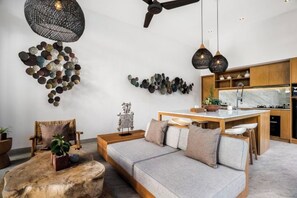 A modern interior with a sofa, a dining area, and a kitchen.