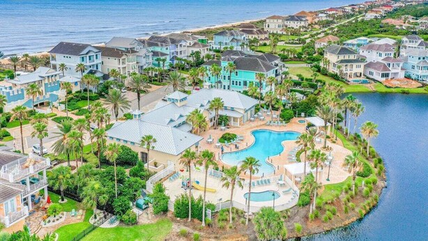 A coastal resort with multiple buildings, a central swimming pool, and a marina. - Elegant waterfront condo with central AC, balcony, and shared pools & hot tubs (Palm Coast)
