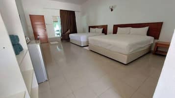 A hotel room with a large bed, a smaller bed, a desk, and a chair.