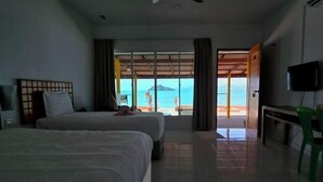 A hotel room with two beds, a TV, and a view of the beach. - Nazrat Residence (Langkawi)