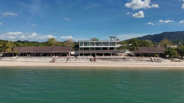 A beachfront hotel with a two-story structure, a pool, and a beach in the foreground. - Nazrat Residence (Langkawi)