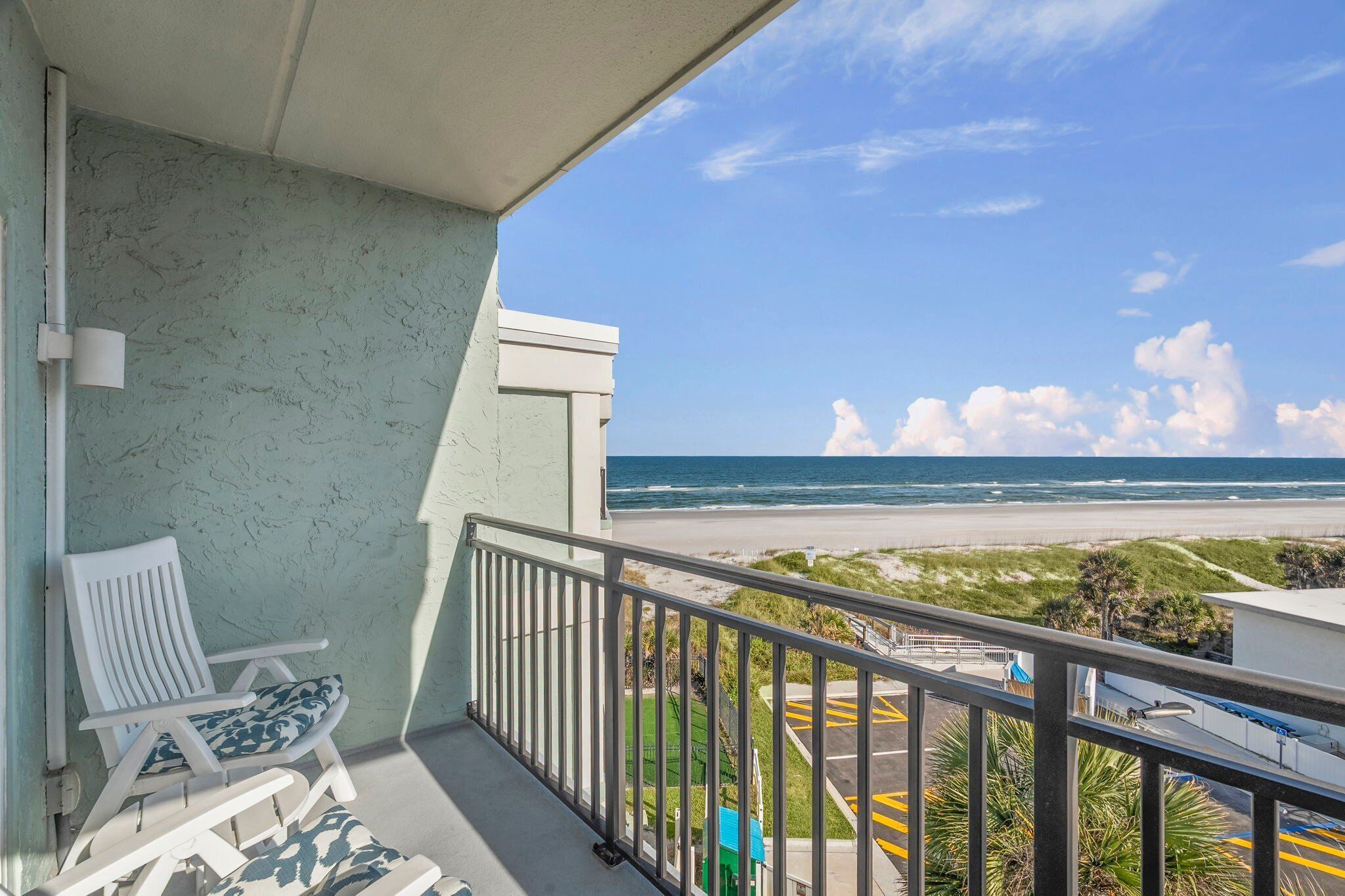 Un balcon avec vue sur la plage et l’océan.