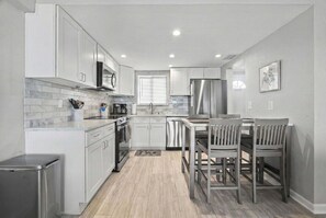 Fridge, microwave, oven, stovetop - Polished oceanfront condo with pool access, private balcony & washer/dryer (Jacksonville Beach)