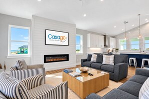 A modern living room with a fireplace, a sofa set, and a coffee table.