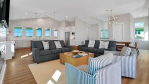 A spacious living area with two sofas, a coffee table, and a striped sofa. - Brand new oceanfront home with private hot tub,outdoor shower and grill (Flagler Beach)