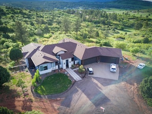 A large house with a garage, a driveway, and a fenced yard.