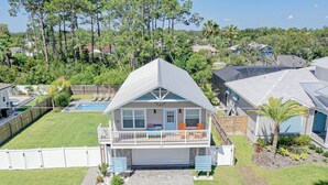 A two-story house with a balcony, a garage, and a well-maintained lawn.