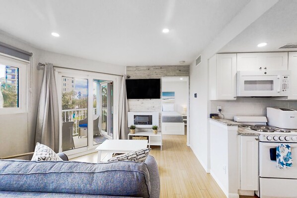 A compact living space with a kitchenette, a dining area, and a sofa.