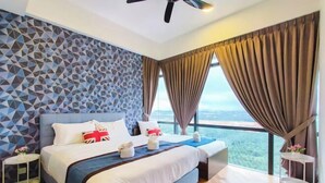 A modern hotel room with a geometric-patterned wall, a large bed with a blue headboard, and a view of the landscape through large windows. - Grand Medini Suites by RR JBcity (Iskandar Puteri)