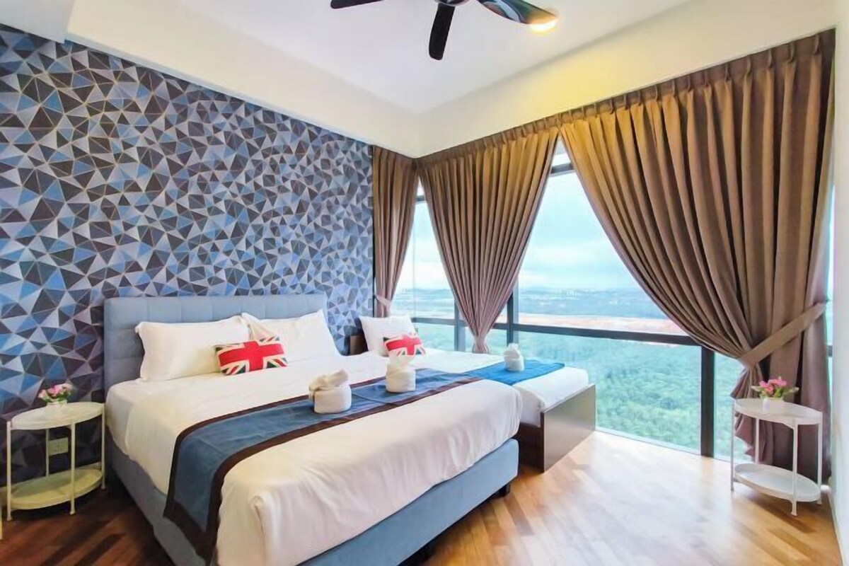 A modern hotel room with a geometric-patterned wall, a large bed with a blue headboard, and a view of the landscape through large windows.