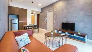 A modern living room with a sofa, TV, and dining area. - Grand Medini Suites by RR JBcity (Iskandar Puteri)