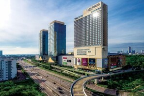 Un grand hôtel à plusieurs étages, avec une enseigne bien visible, situé en bordure d’une autoroute très fréquentée.