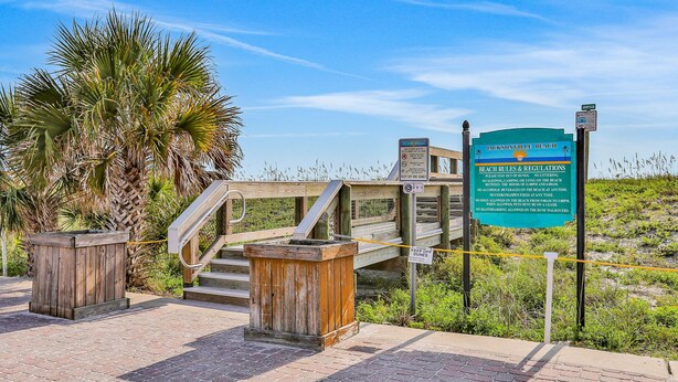A wooden staircase leading to a beach area with a sign detailing beach rules and regulations. - Cozy Spacious Home with Private Backyard and Patio, near shopping (Jacksonville)