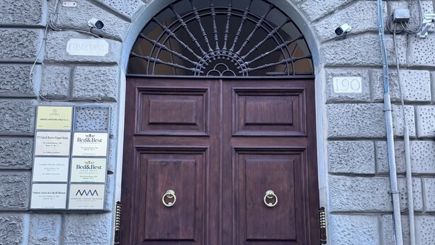 A double wooden door with a metal grill above it, set in a stone building. - Beauty House in Cola di Rienzo• 4 Bedrooms - 2 Baths - St. Peter's, Central Rome (Roma)