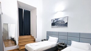 A hotel room with two beds, a large mirror, a staircase, and a framed picture of the Colosseum. - Beauty House in Cola di Rienzo• 4 Bedrooms - 2 Baths - St. Peter's, Central Rome (Roma)