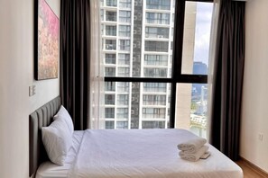 Une chambre d’hôtel avec un grand lit, une fenêtre avec des rideaux et une vue sur la ville.