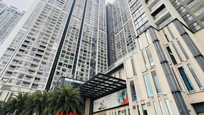 A high-rise building with multiple floors, large windows, and a modern architectural design. - Hopo Housing - Vinhomes Skylake Apartment Luxury Hanoi (Hanoi)