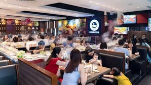 A restaurant with booths and tables, a sushi bar, and a large digital screen displaying food. - Hopo Housing - Vinhomes Skylake Apartment Luxury Hanoi (Hanoi)
