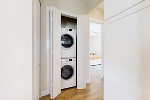 A laundry room with two stacked washing machines.