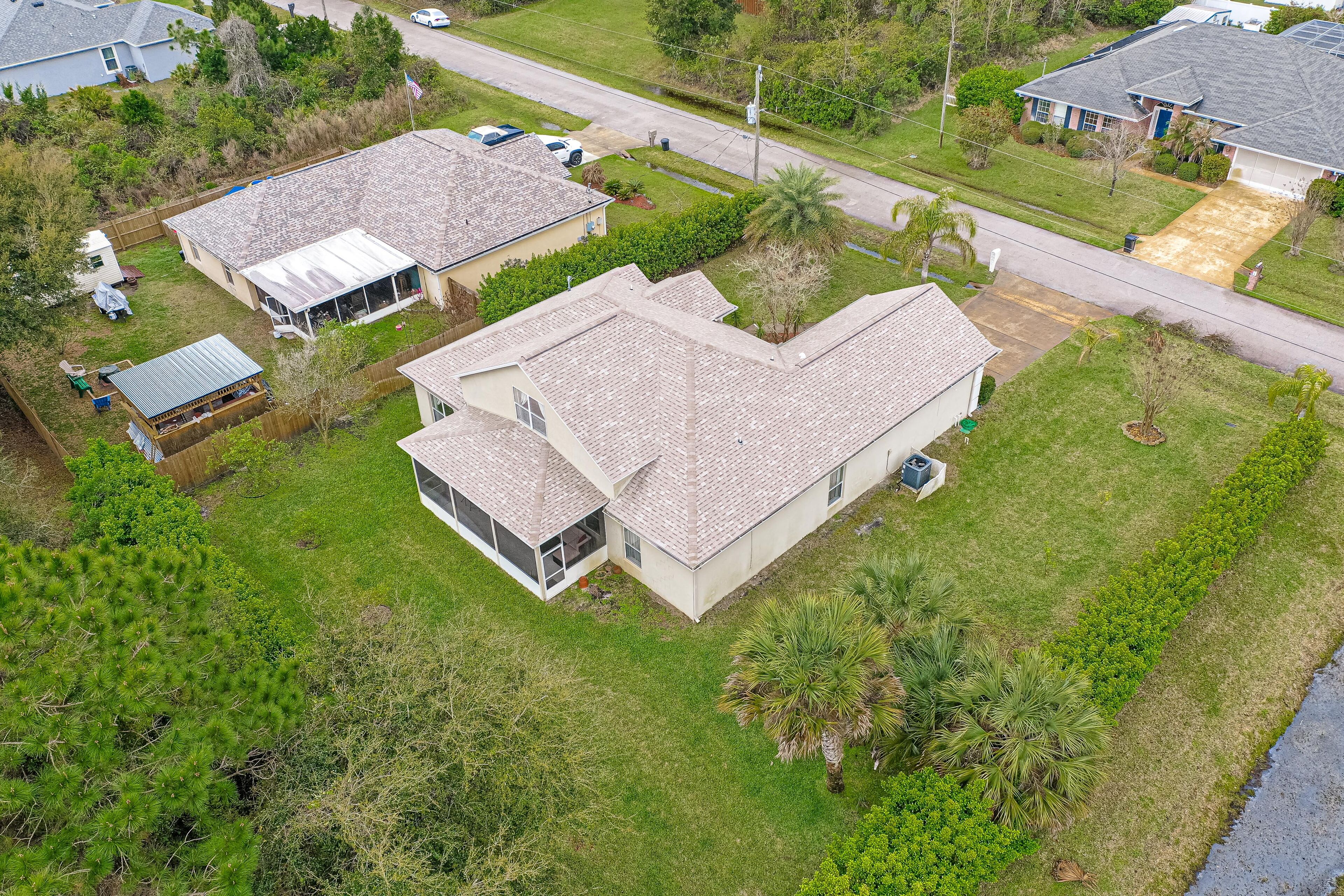 A residential area with two houses, one with a large garage and another with a covered patio.