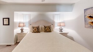 Un dormitorio con una cama grande, dos mesitas de noche con lámparas y un cuadro en la pared.