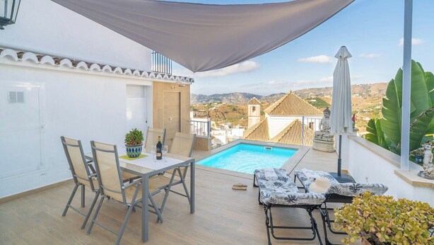 A poolside area with a table and chairs, a small pool, and a view of the surrounding landscape. - Casa Loli Frigiliana by Ruralidays (Málaga)