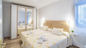A hotel room with a large bed, a wardrobe, and a window with a view. - Casa Loli Frigiliana by Ruralidays (Málaga)